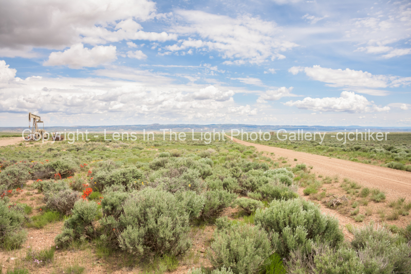Dirt-Road-With-Oifield-Tanks-In-Background