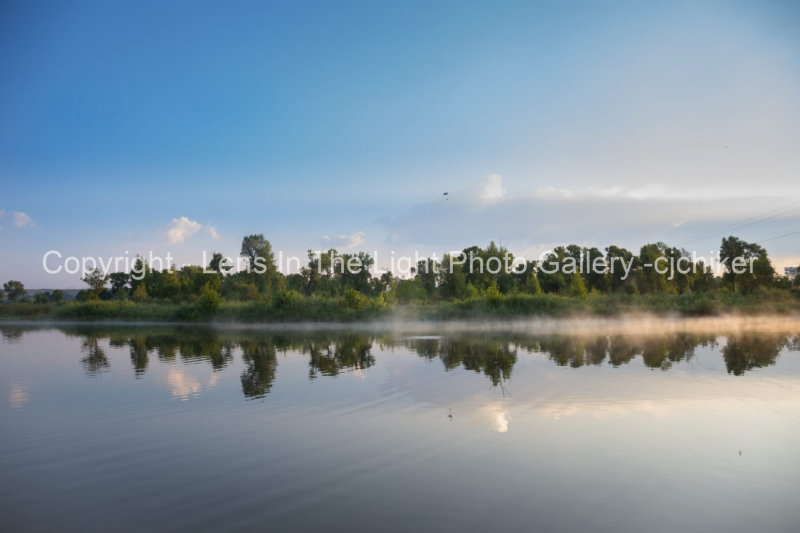 Trees-Along-Shorline-On-Pond-With-Mist-In-Sunlight